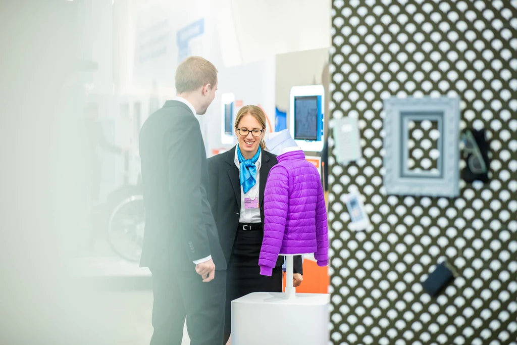 2 people talking at an exhibition stand.