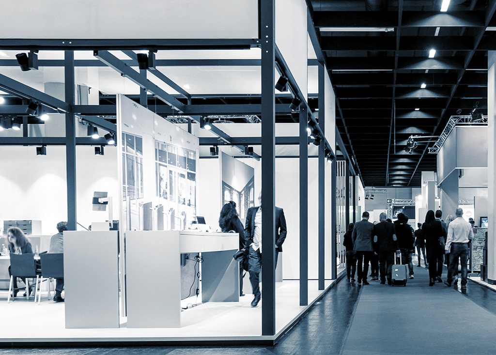 people walking through an exhibition hall with lots of stands and displays using adhesive tapes